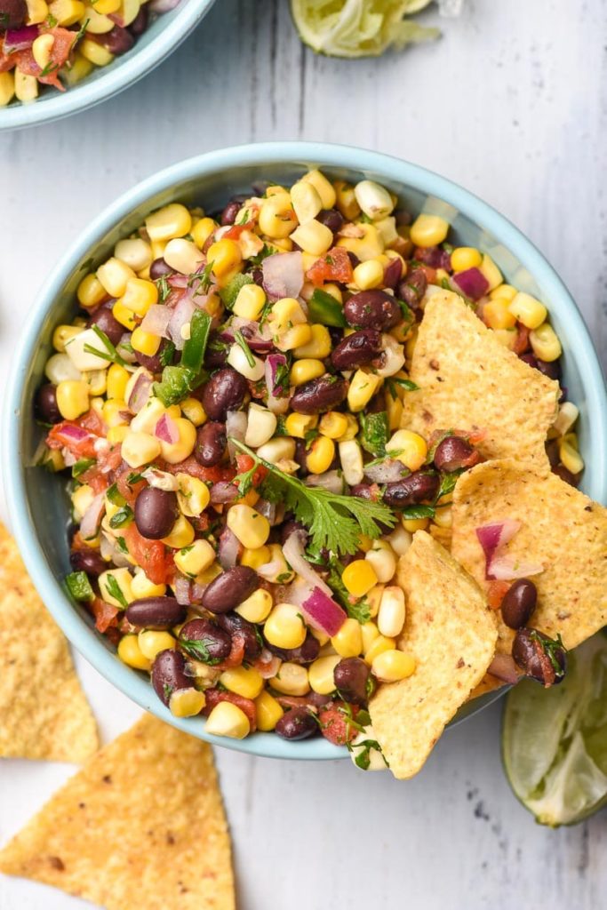 salsa made with black beans and corn in a bowl with tortilla chics