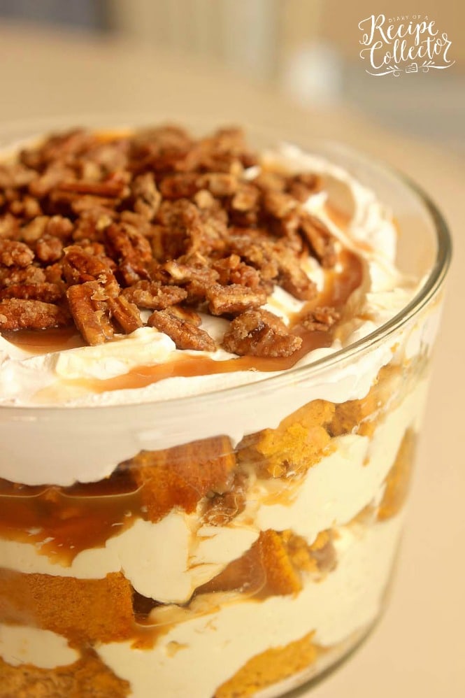 a trifle dish with layers of pumpkin cake, and white creamy filling, topped with walnuts