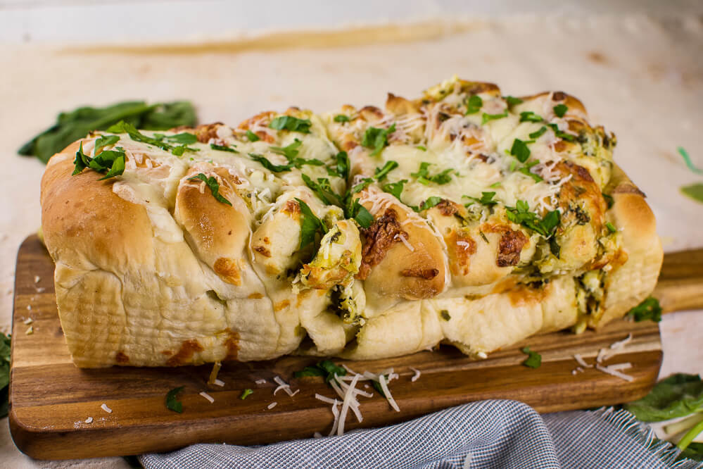 a loaf of cheeesy pull apart bread with chopped parsley on top. Little Dairy on the Prairie