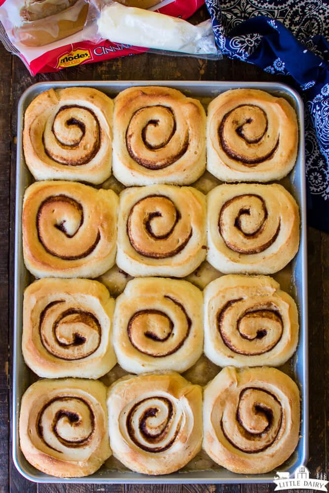 a pan with baked cinnamon rolls and an icing packet