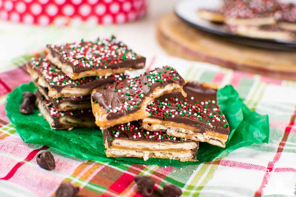 Christmas Crack Candy stacked on a piece of green tissue paper and a plaid napkin