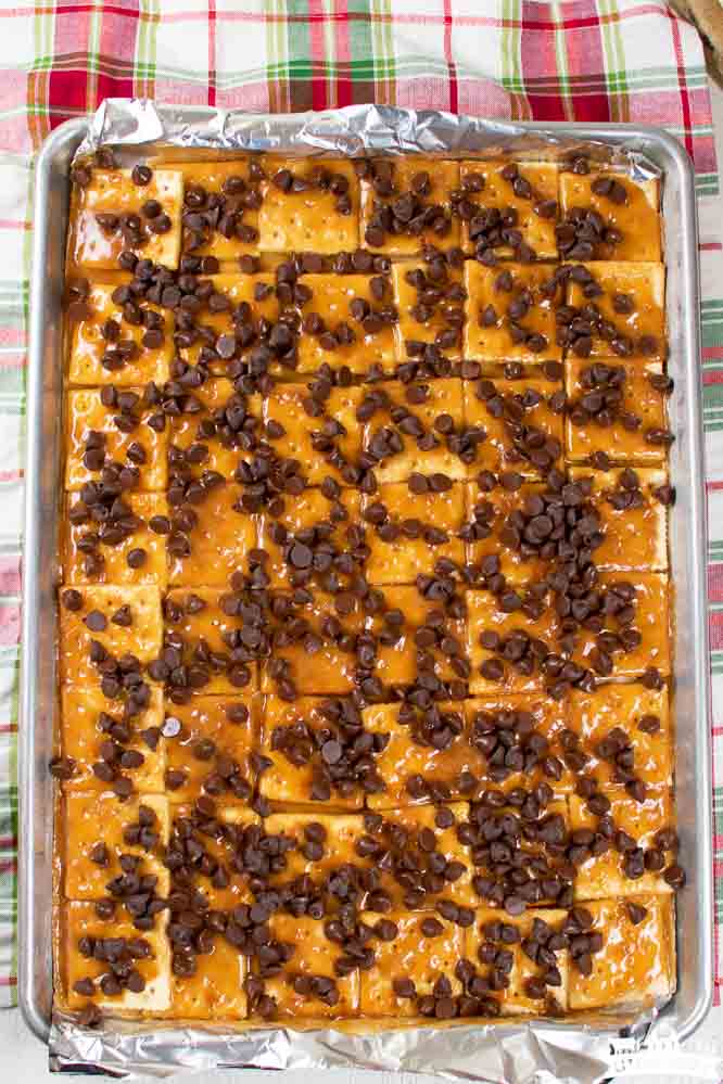 a sheet pan with soda crackers, a caramel layer, and chocolate chips