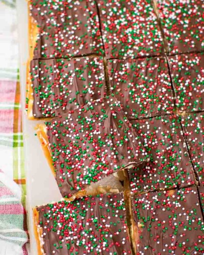a cutting board with Christmas Crack candy cut into squares