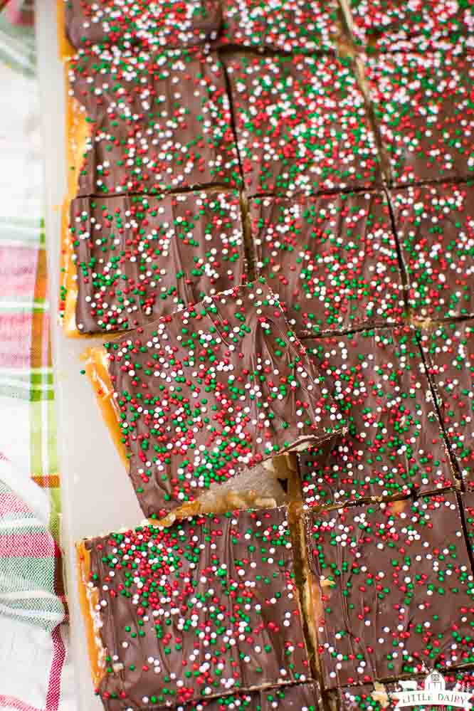 a cutting board with Christmas Crack candy cut into squares