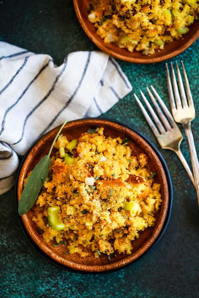 corn bread stuffing in a wooden bowl with a fresh sage leaf