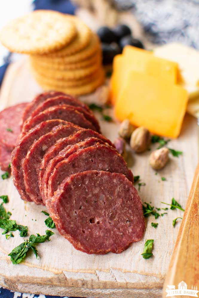slices of homemade summer sausage with slices of cheese and crackers