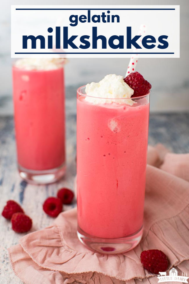 thick milkshake in a tall glass topped with whipped cream, a raspberry, and a straw