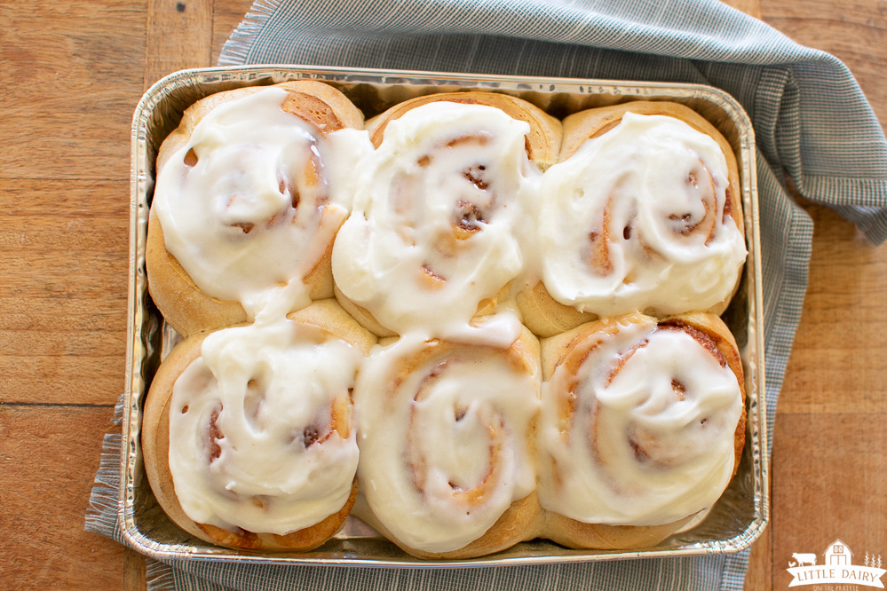 a tin pan with baked and frosted 30-minute cinnamon rolls