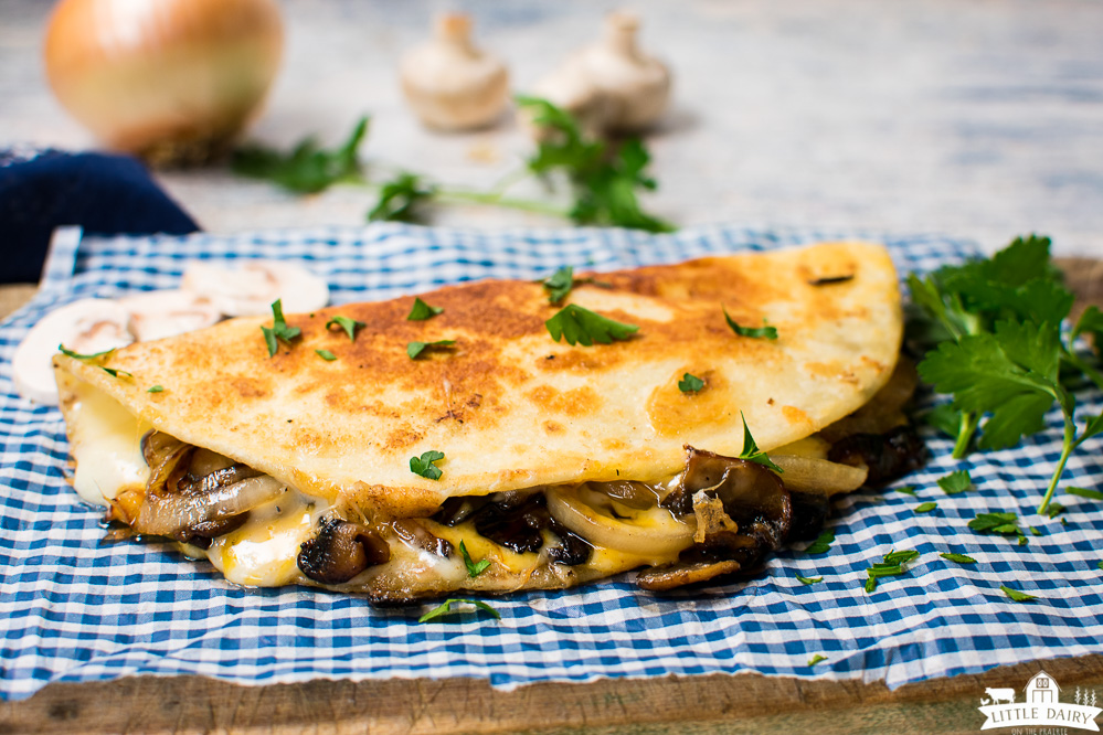 a tortilla stuffed with mushrooms, onions, and pork folded in half and fried until golden brown