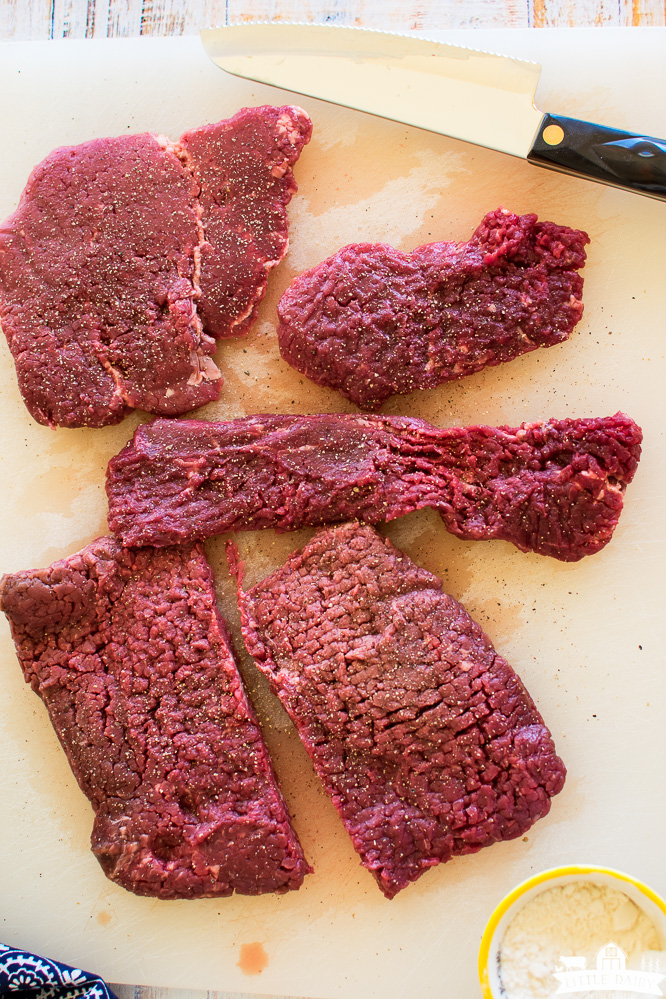 Raw cube steaks on a cutting board.