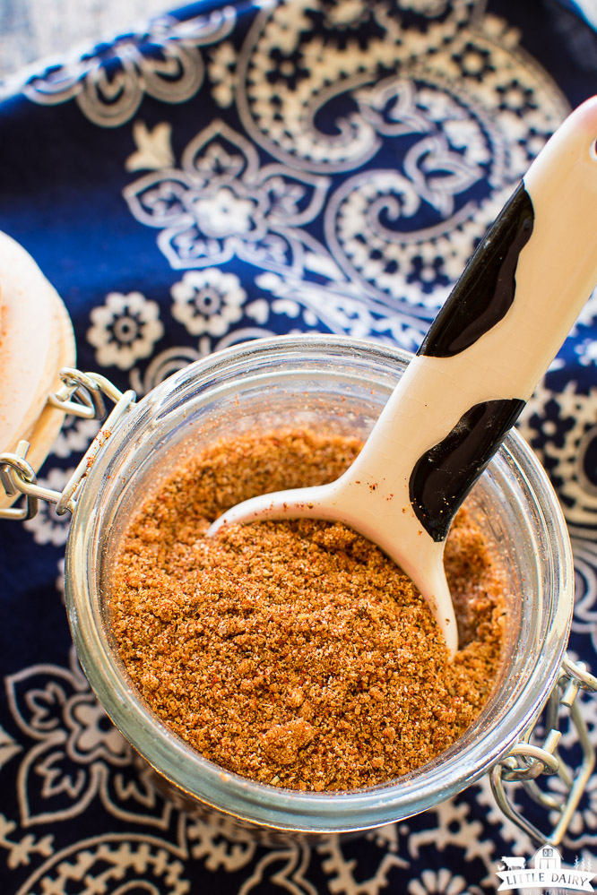 brick red dry seasoning in a glass jar with a navy blue napkin underneath