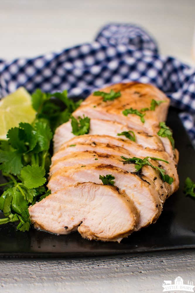 Sliced grilled chicken with limes and cilantro.