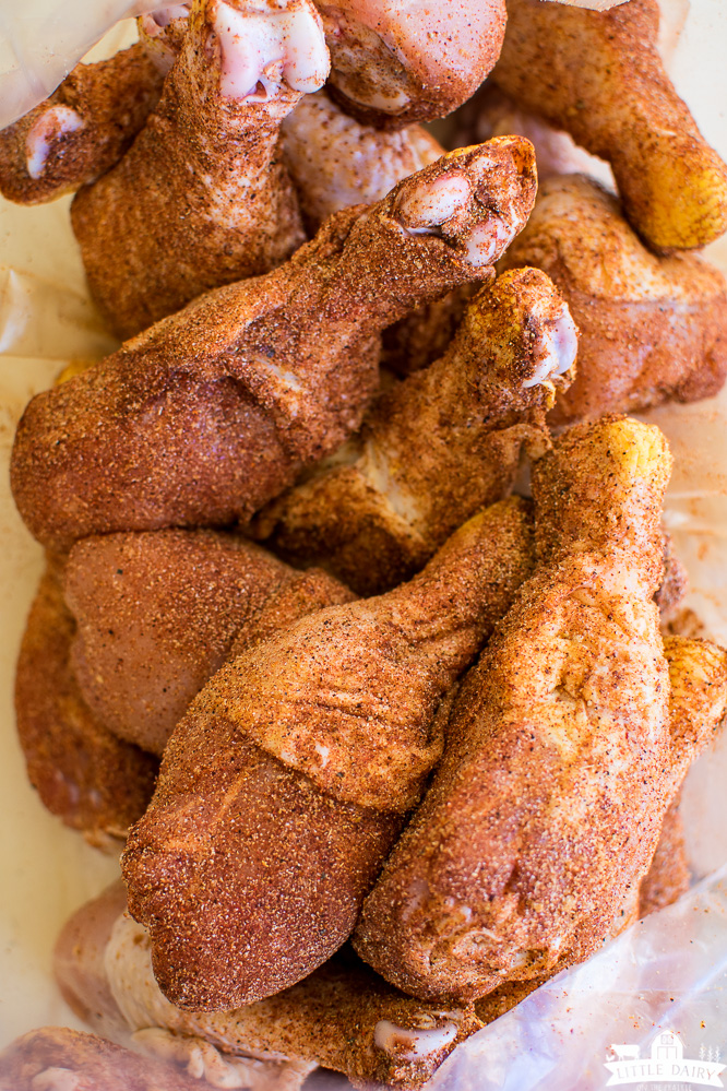 chicken legs in a slow cooker liner bag that are coated with bbq rub