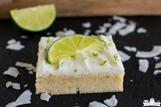 a bar cookie topped with white icing and a lime wedge
