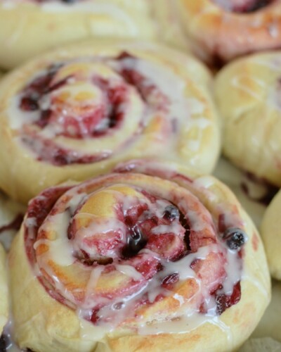 a pan with baked blueberry sweet rolls and icing