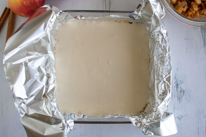 a square baking dish lined with foil and filled with unbaked cheesecake filling
