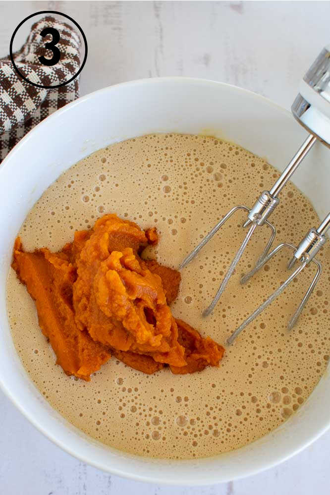 a bowl with beaten eggs and pumpkin puree