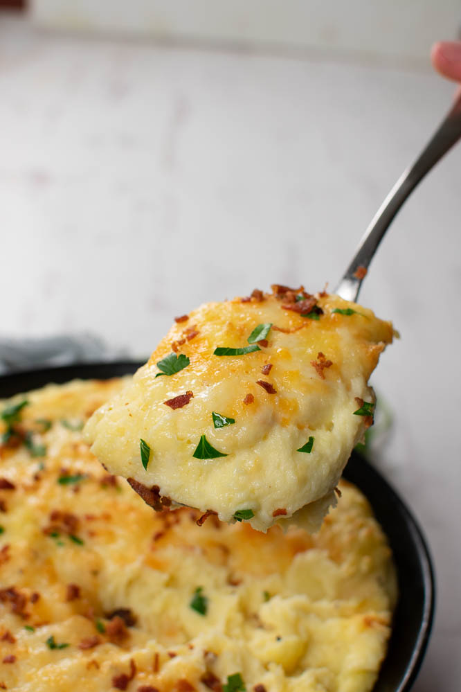 a spoonful of mashed potatoes with cheese and bacon