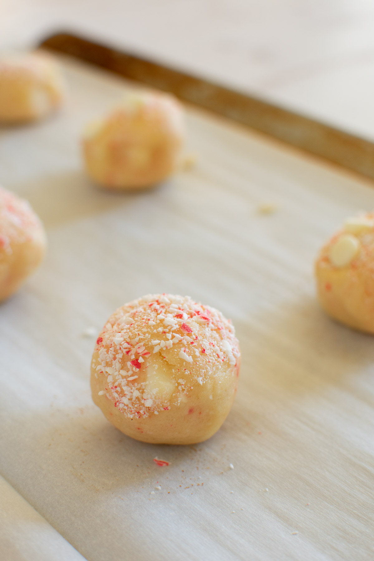 Sugar cookie dough balls rolled in crushed candy canes.