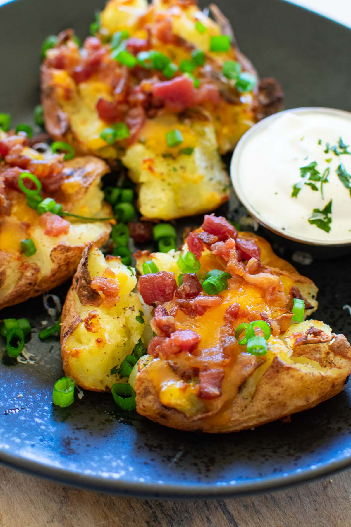 Loaded smashed potatoes with bacon, cheddar cheese, and green onions.