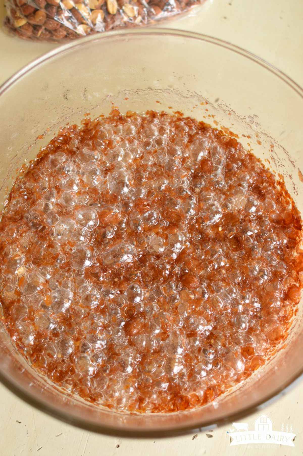 A bowl with bubbling dark nut brittle mixture. 