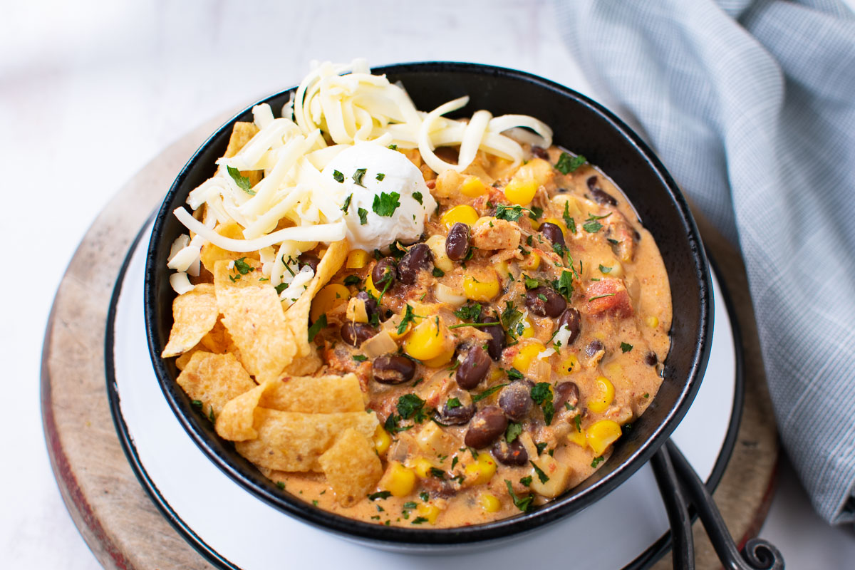 Chicken taco soup with corn chips, cheese, and sour cream.