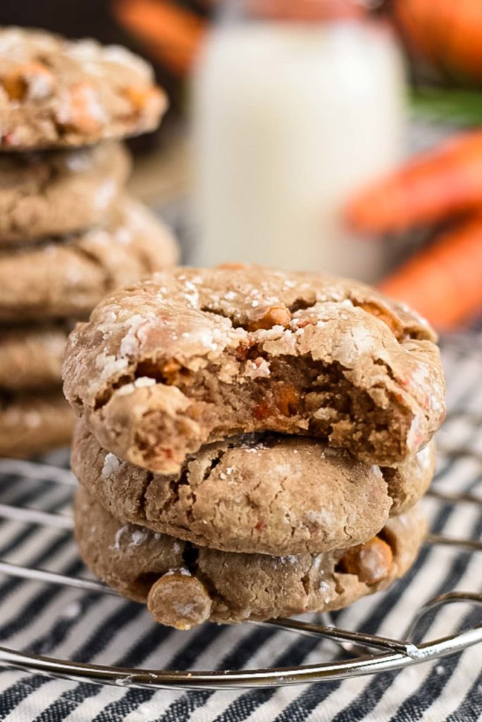 A stack of carrot cookies with a bite taken out of one.