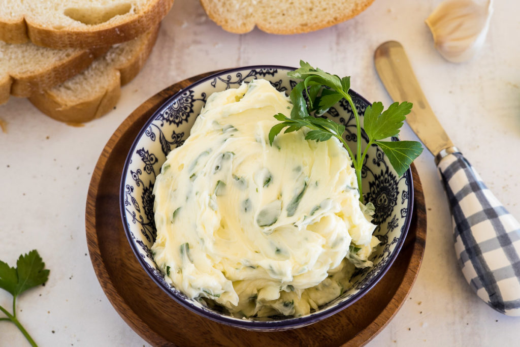 A bowl of garlic butter with herbs.