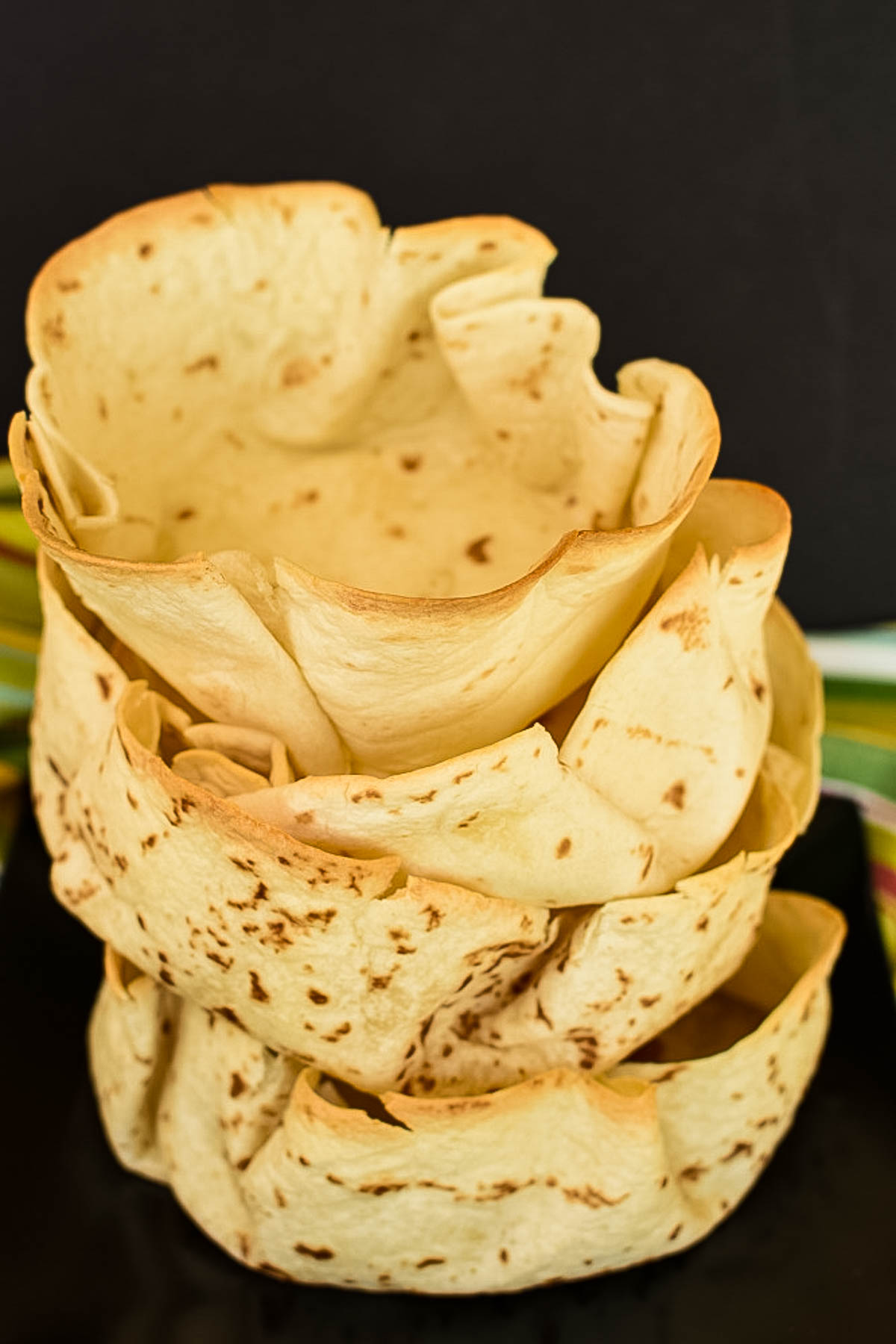 A stack of oven baked tortilla taco bowls.