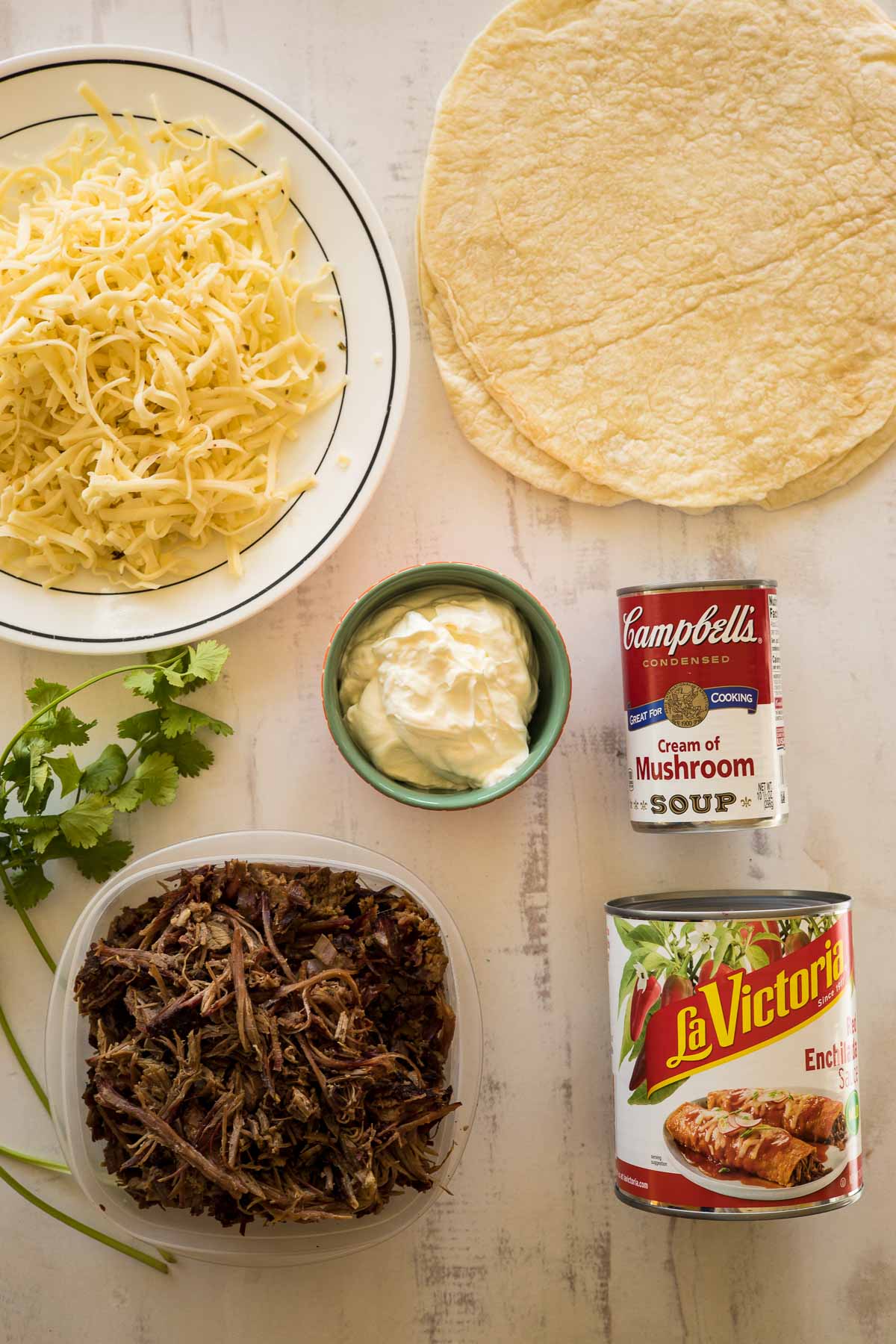 Ingredients needed to make enchiladas with shredded beef.