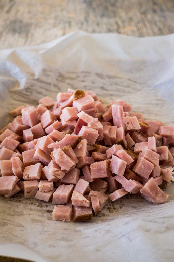 Diced cooked ham on a piece of parchment paper.