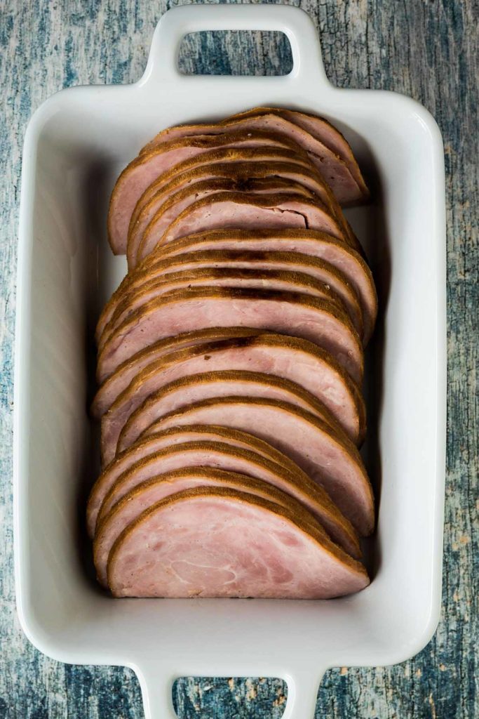 Sliced ham in a baking dish.