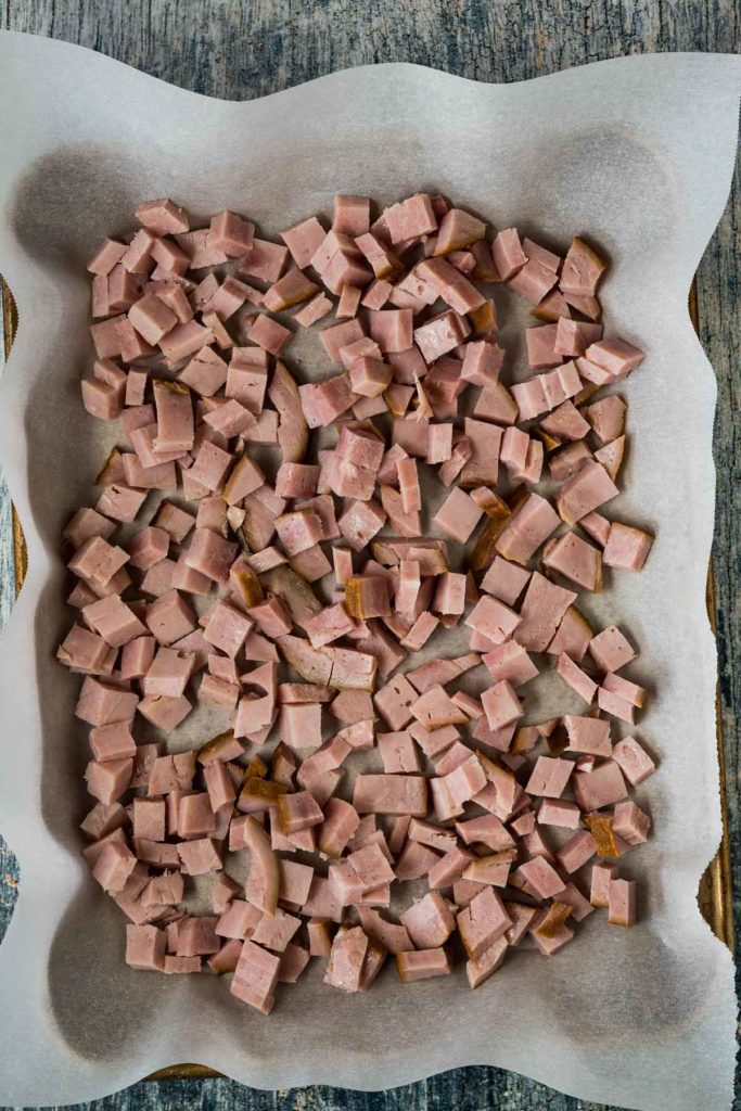 Diced cooked ham on a baking sheet.