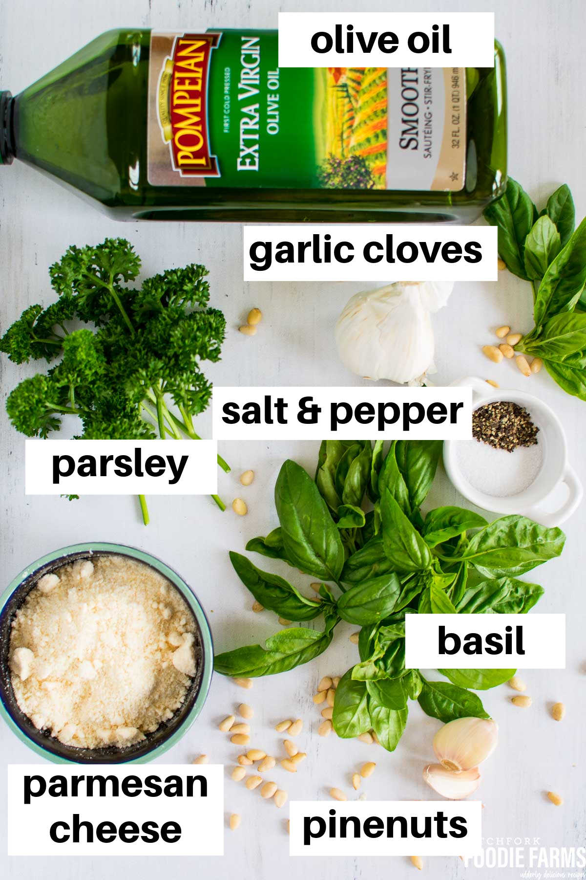 Ingredients needed to make pesto sauce on a white board.