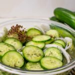 Cucumber salad in a glass bowl with dill.