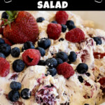 An image with text and a picture of a creamy fruit salad with fresh berries on top.