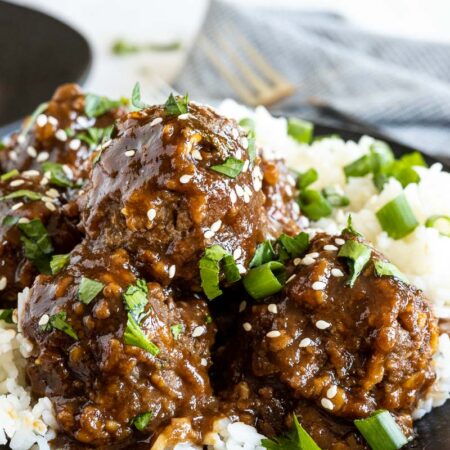 Meatballs in sweet and sour sauce on top of white rice.
