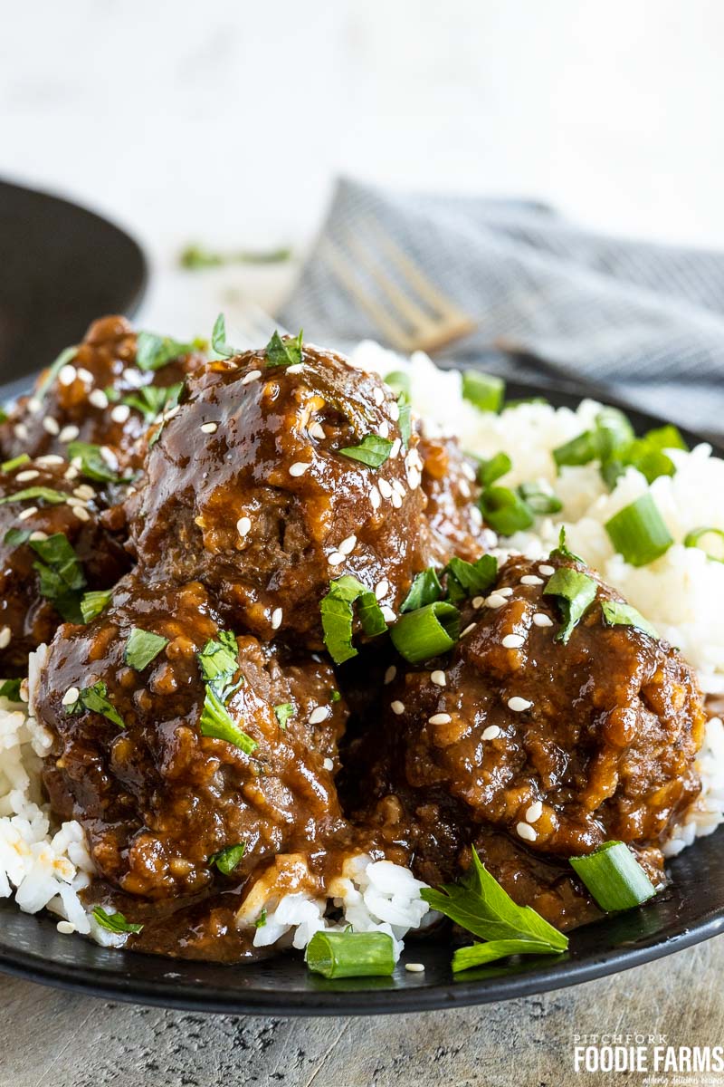 Meatballs in sweet and sour sauce on top of white rice.