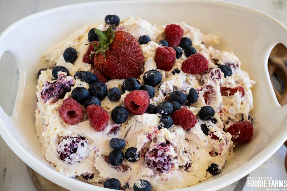 Cheesecake salad with fresh mixed berries on top.