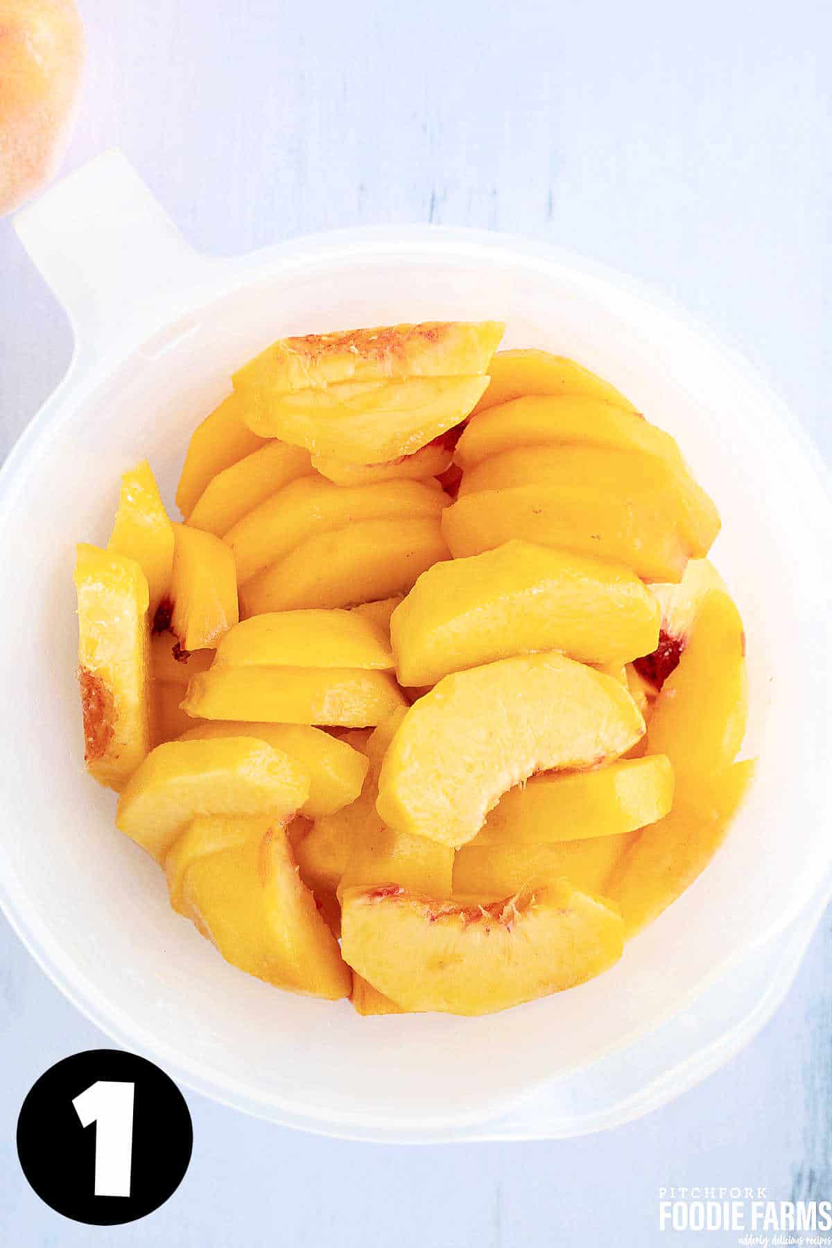Sliced Peaches in a white measuring cup.