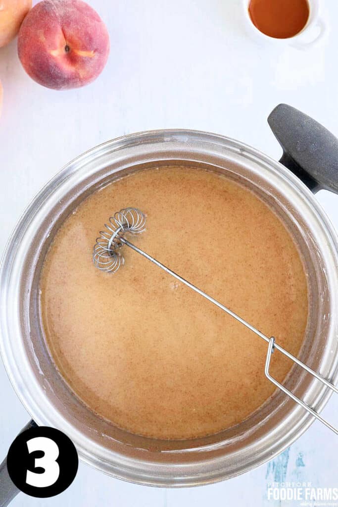 Brown sugar and water in a saucepan with a whisk for making pie filling.