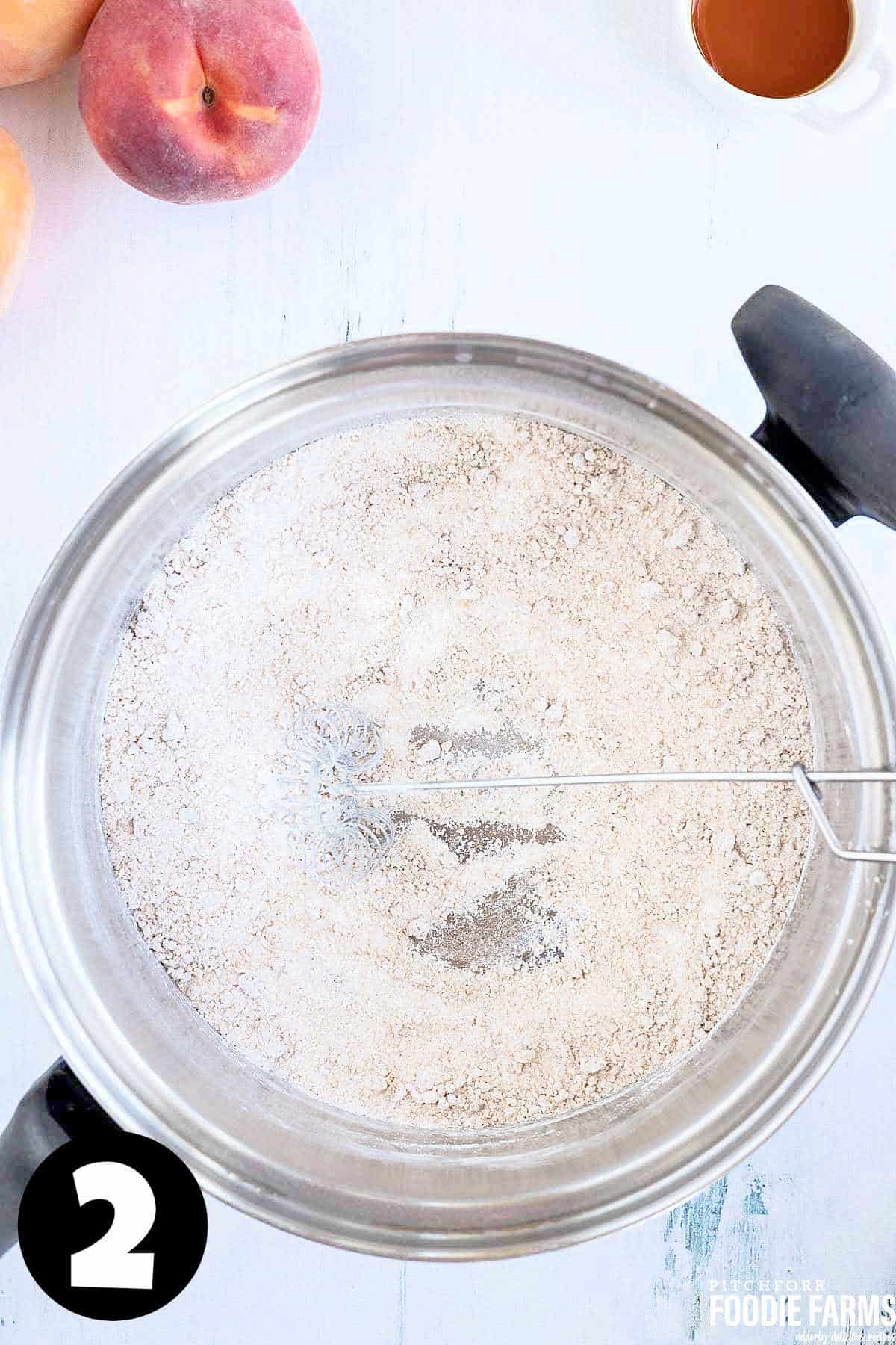 Sugar, cinnamon, and cornstarch whisked together in a metal saucepan.