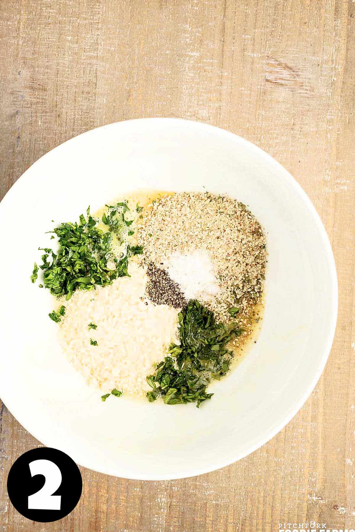 Parmesan cheese, herbs, breadcrumbs, and seasonings in a mixing bowl.