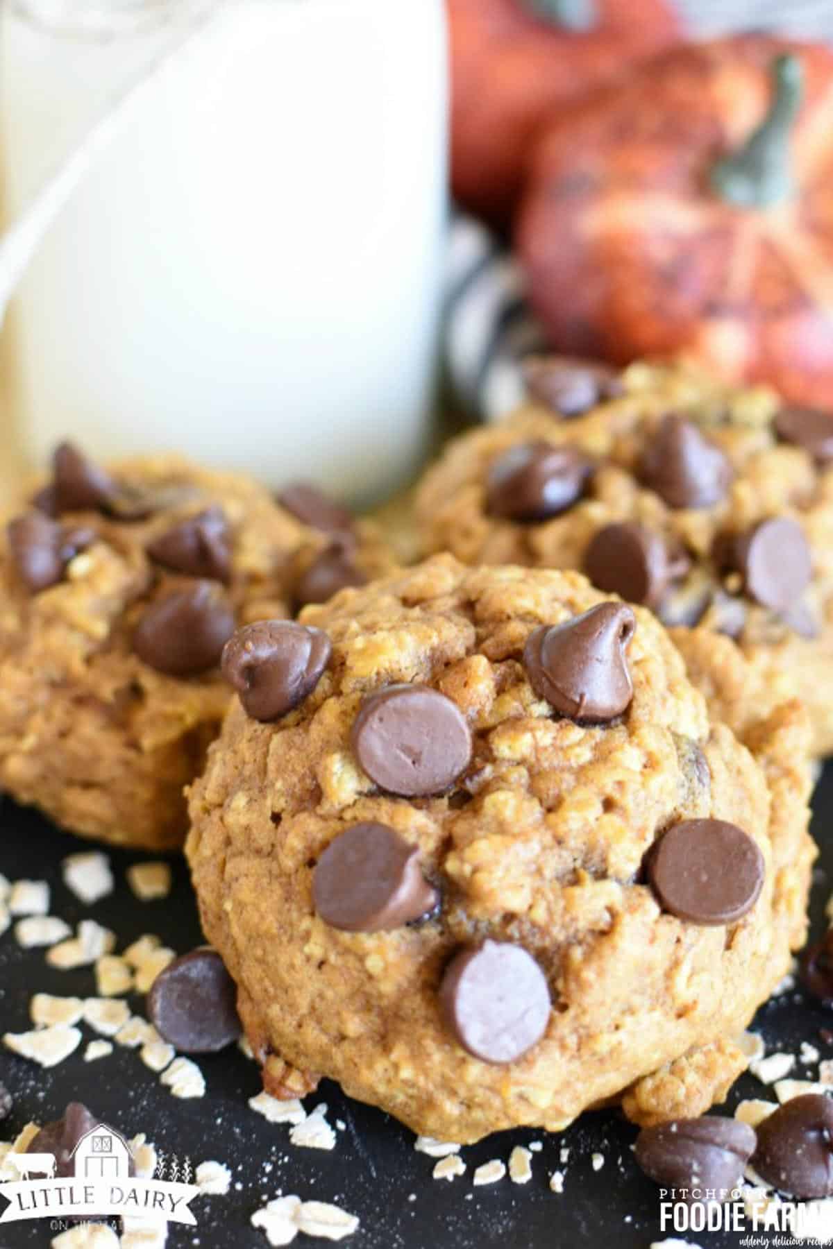 Pumpkin cookies with oatmeal and chocolate chips. on a cooling rack with a glass of milk. 