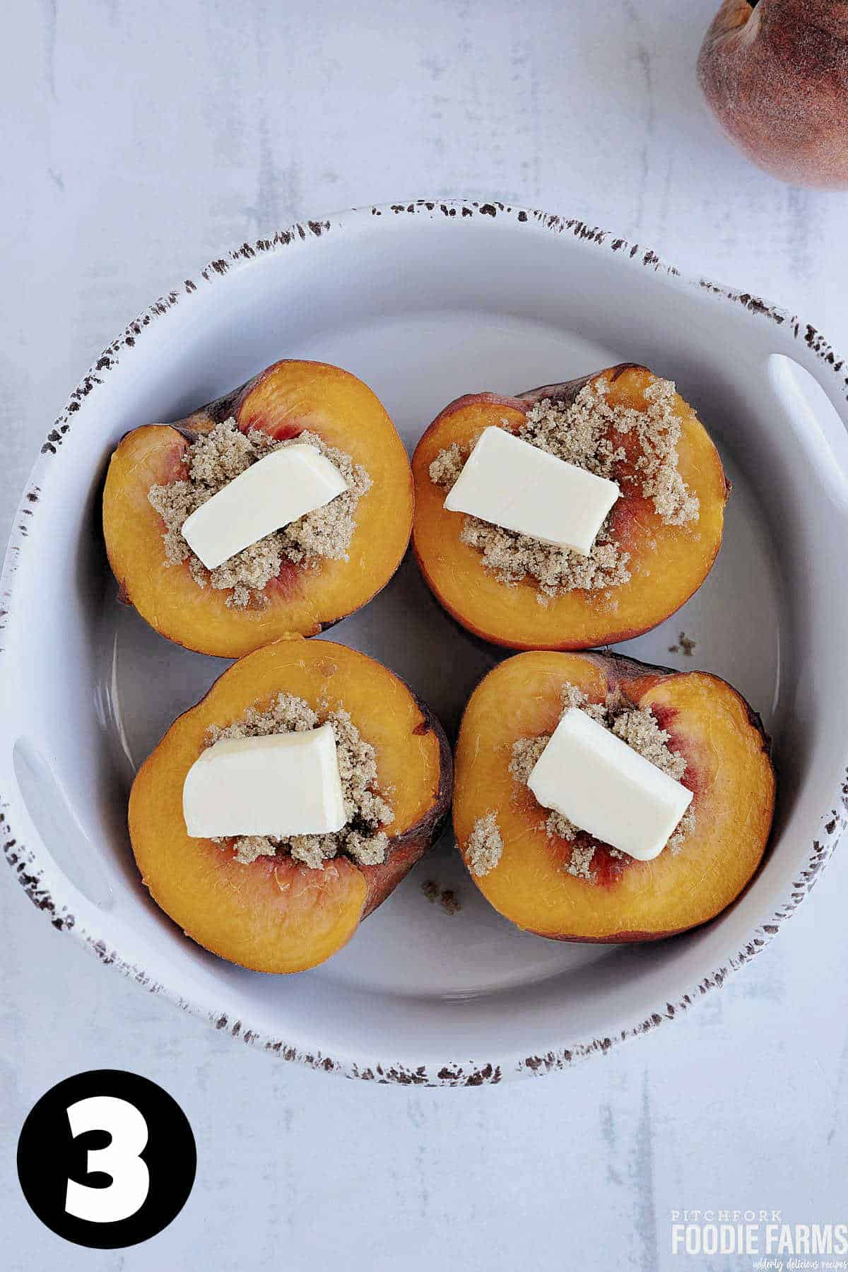 Fresh peaches with brown sugar and butter in a baking dish.