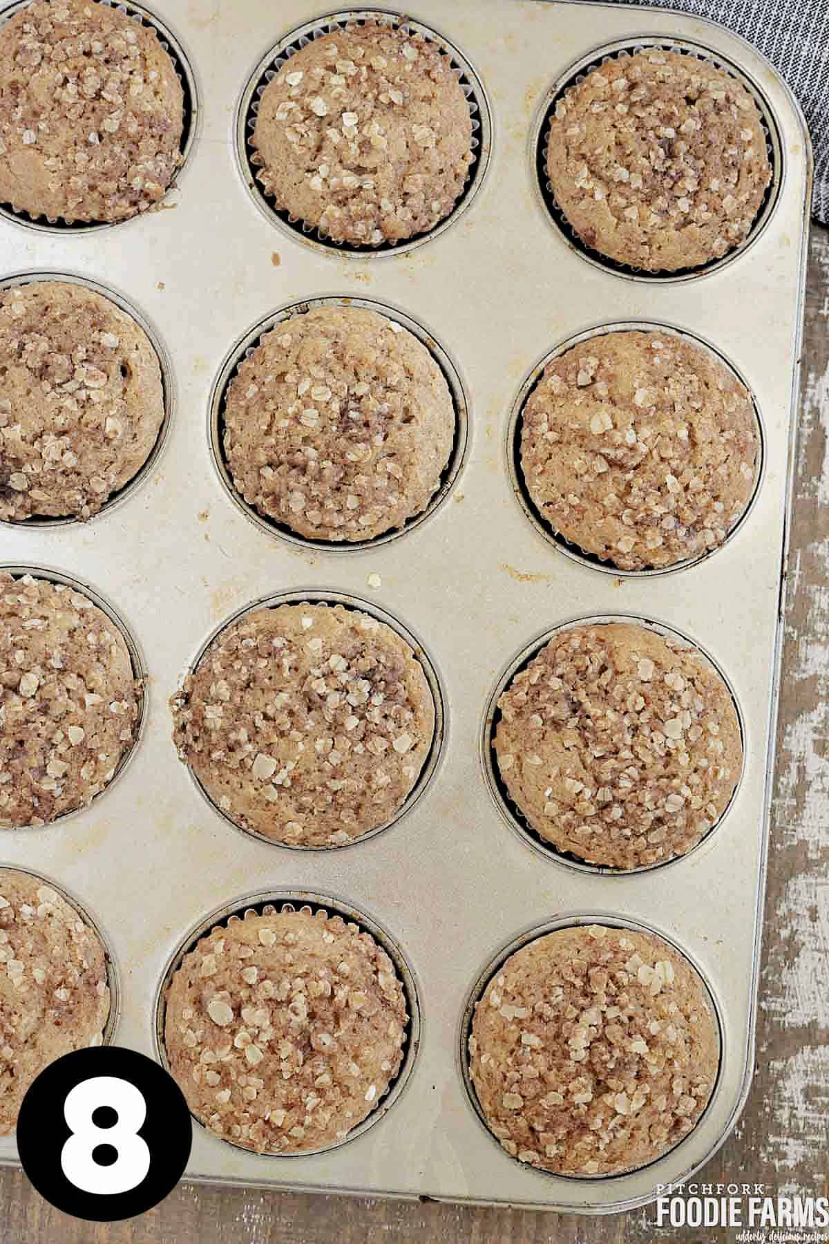 A cupcake pan with streusel topped muffins.