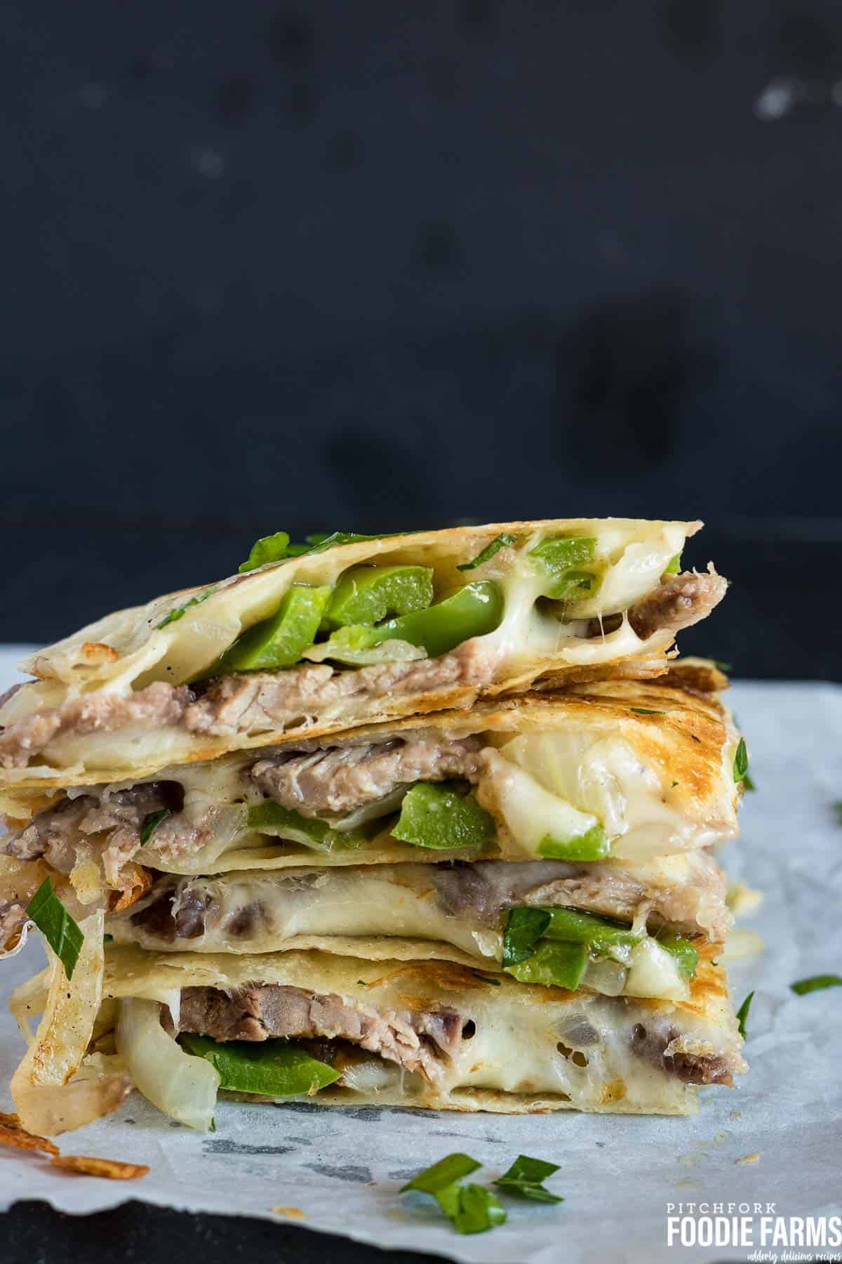 A stack of quesadilla wedges with steak and green peppers.
