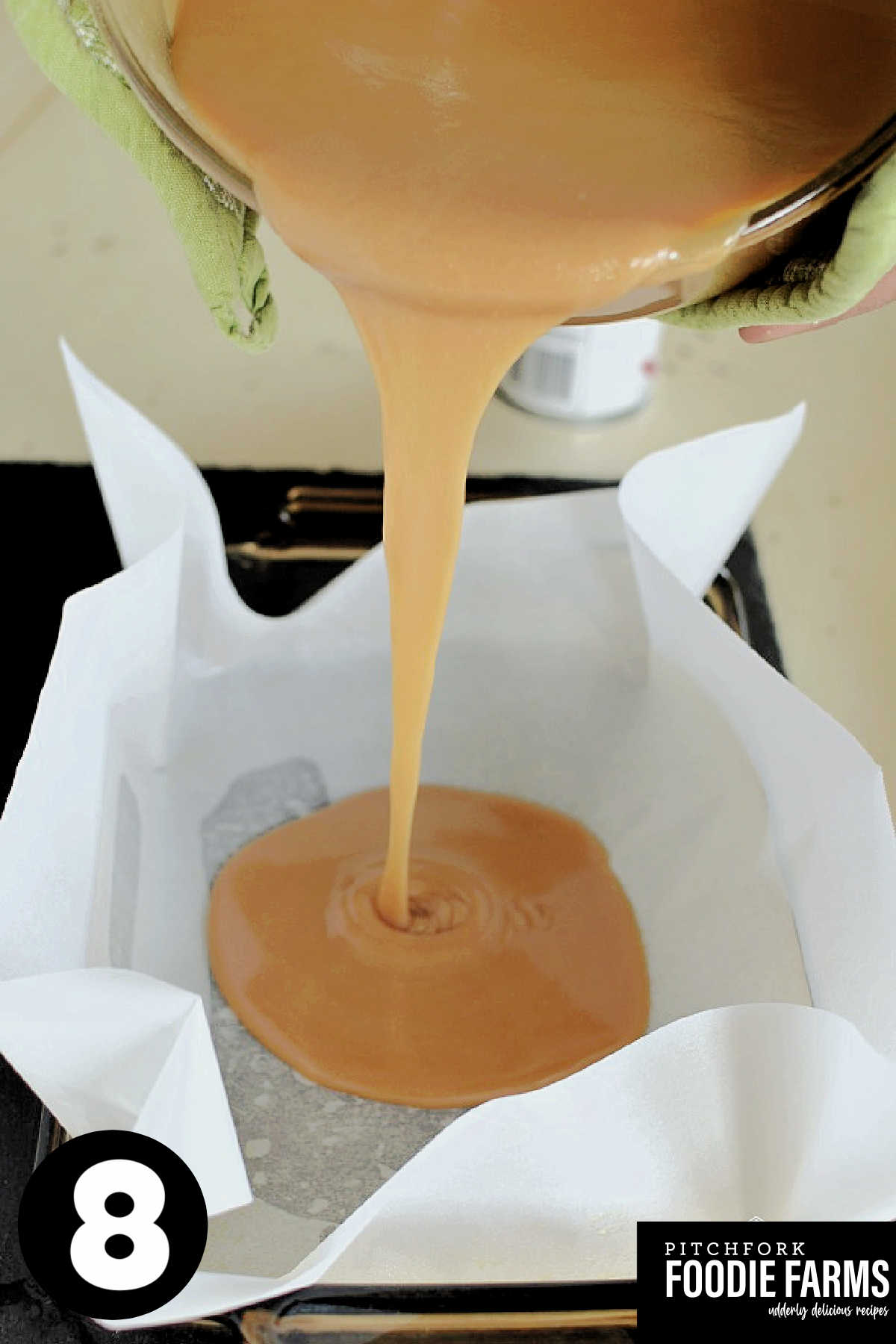 Caramel candy being poured into a parchment paper lined baking dish.