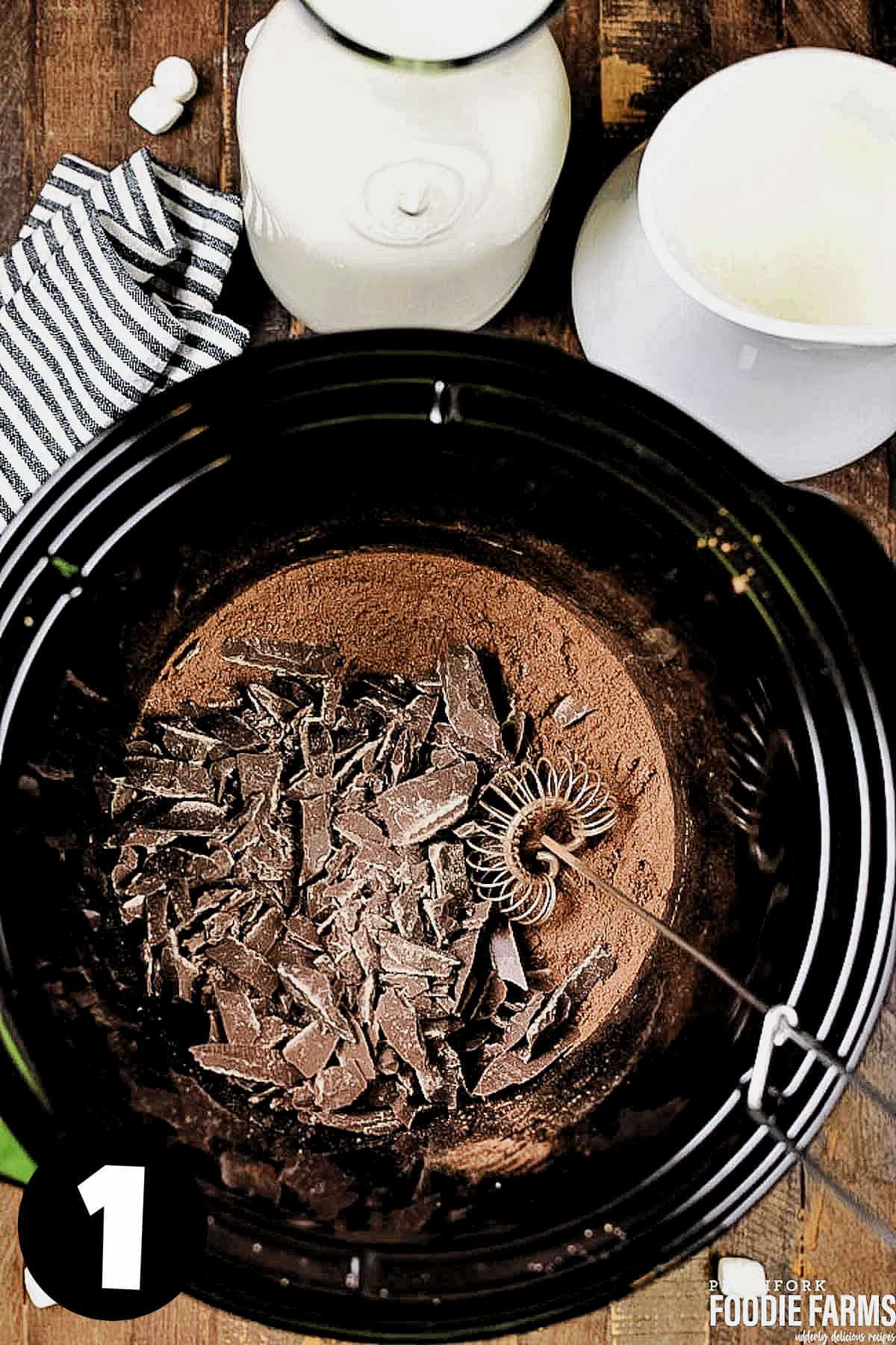 Chocolate and cocoa in a crockpot with a whisk.