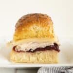 A turkey slider with cranberry sauce on a sweet Hawaiian roll.